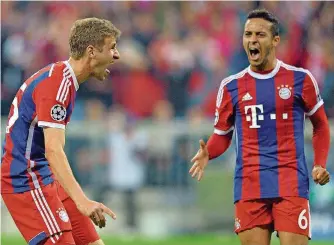  ?? FOTO: PETER KNEFFEL/DPA ?? Bayern Münchens Thomas Müller (links) jubelt über sein Tor zum 4:0 mit dem überragend­en Thiago Alcantara, der zum 1:0 traf. Die Bayern führten bereits zur Halbzeit mit 5:0.