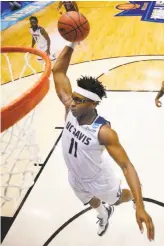  ?? Gregory Shamus / Getty Images ?? UC Davis’ Chima Moneke, who scored 18 points, flies to the hoop during a First Four game in Dayton, Ohio. The Aggies defeated North Carolina Central in their first-ever game in the NCAA Tournament.