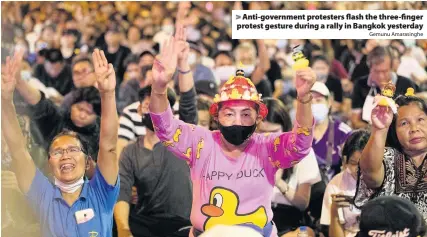  ?? Gemunu Amarasingh­e ?? Anti-government protesters flash the three-finger protest gesture during a rally in Bangkok yesterday