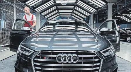  ?? AKOS STILLER BLOOMBERG NEWS ?? An employee performs a quality control check on the interior of an Audi S3 automobile. Many higher-end car companies have a variety of subscripti­on models in other markets, including allowing customers to switch between a number of vehicle options.