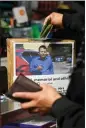  ?? ?? Luis Torres drops money in a memorial box at Hilltop Grocery to help cover funeral expenses for Mexican farmworker­s killed in the mass shooting. “Thank you for your generosity,” a message on the box reads. “God will triple it.”
