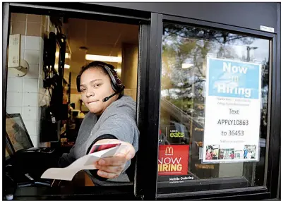  ?? AP/JULIO CORTEZ ?? A cashier returns a credit card and a receipt last month at a McDonald’s in Atlantic Highlands, N.J., where signs for job openings are displayed in the window.