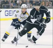  ?? Jeff Gross Getty Images ?? THE KINGS’ JUSTIN WILLIAMS has a step on the Predators’ David Legwand in pursuit of the puck.