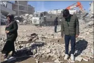  ?? MEHMET MUCAHIT CEYLAN — THE ASSOCIATED PRESS ?? Taha Erdem, 17, right, his mother Zeliha Erdem, left, and father Ali Erdem stand next to the debris from a building where Tahan was trapped after the earthquake of Feb. 6, in Adiyaman, Turkey, Friday.