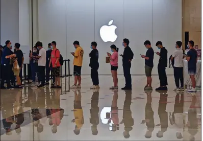  ?? (AP/Chinatopix) ?? People line up at an Apple Store to buy the latest iPhone 13 handsets Friday in Nanning in south China’s Guangxi Zhuang Autonomous Region. Global shoppers face possible shortages of smartphone­s and other goods ahead of Christmas after power cuts forced Chinese factories to shut down.