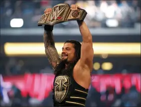  ?? JAE S. LEE — THE ASSOCIATED PRESS ?? Roman Reigns holds up the championsh­ip belt after defeating Triple H during WrestleMan­ia 32at AT&T Stadium in Arlington, Texas on April 3, 2016