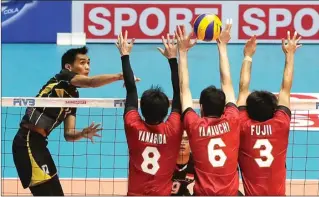  ?? GALIH COKRO/JAWA POS ?? SULIT TEMBUS: Open spiker Indonesia Rivan Nurmulki (kiri) melepaskan spike dalam hadangan tiga pemain Jepang pada semifinal di GOR Tri Dharma Petrokimia, Gresik, kemarin.