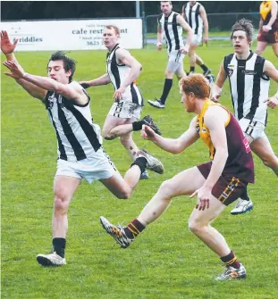  ??  ?? David Miller, a consistent defender for Drouin this year, beats a smothering attempt by a Sale opponent to send his team forward during Saturday’s senior match.