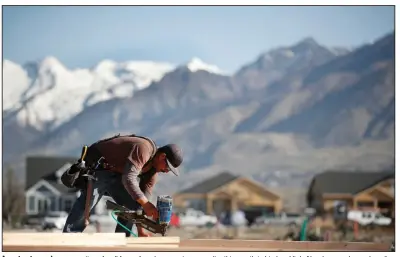  ?? (Bloomberg News/George Frey) ?? A contractor works on a section of wall frame for a house going up earlier this month in Lindon, Utah. New home sales and median home prices fell in March, according to U.S. reports.