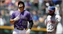  ?? THE ASSOCIATED PRESS ?? Colorado’s Nolan Arenado, left, gestures as he reaches second after hitting a double to drive in two runs as Mets shortstop Amed Rosario looks on during Thursday’s game.