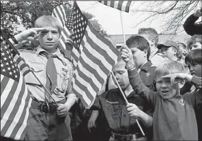  ?? AP/RICHARD RODRIQUEZ ?? Joshua Kusterer (from left), Nach Mitschke and Wyatt Mitschke salute Wednesday as they recite the Pledge of Allegiance during the Save Our Scouts vigil and rally in front of the Boy Scouts of America national headquarte­rs in Irving, Texas.