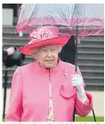  ??  ?? Her Majesty dressed in a bright pink outfit shelters from the rain at a garden party