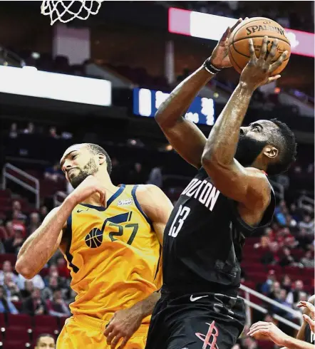  ?? — AP ?? Get out of my way: Houston Rockets guard James Harden (right) drives to the basket as Utah Jazz centre Rudy Gobert defends during the first half of their NBA game on Monday.