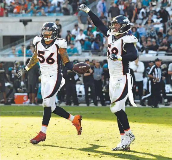  ??  ?? Broncos outside linebacker Shane Ray, left, celebrates his fumble recovery during the fourth quarter Sunday in Jacksonvil­le, Fla. The fumble was caused on a tremendous play by Von Miller, right, who forced Jaguars quarterbac­k Blake Bortles to fumble by...