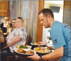  ?? FILE PHOTO / The Saline Courier ?? Benton Police Captain Kevin Russell serves a tray of food at Colton’s
Steak House & Grill’s 2023 Tip-a-cop fundraiser.