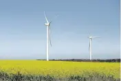  ?? CARLA GOTTGENS Bloomberg ?? Wind turbines stand amid a field of canola plants near Fiskville, Australia. The world’s biggest lenders generated a total of about $3 billion in fees last year from underwriti­ng bonds and providing loans for projects marketed as environmen­tally friendly.