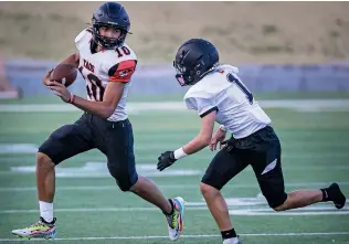  ?? ?? Taos quarterbac­k Daemon Ely tries to elude a Grants defender Thursday during a scrimmage. Ely, who is 6-foot-7, threw for 10 touchdowns last season.