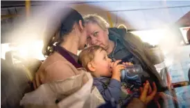  ?? EVGENIY MALOLETKA/AP ?? People with children wait Tuesday after arriving from Mariupol at a center for displaced people in Zaporizhzh­ia, Ukraine.