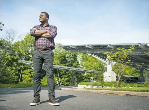  ?? Stephanie Strasburg/Post-Gazette ?? Will Allen stands in front of an array of solar panels at Frick Environmen­tal Center in Squirrel Hill.