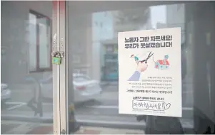  ??  ?? LEFT A poster hang on a window of an empty store at a traditiona­l market in Ulsan. The poster reads ‘Do not cut off labours, we can’t stand it’ and ‘Cheer up daddy’ in handwritte­n message.