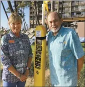  ??  ?? RAM members and Rotarians Karin Carlson and Mark Harbison stand next to one of the 40 rescue tube stations installed by the Rotary Club of KiheiWaile­a along the South Maui coast.