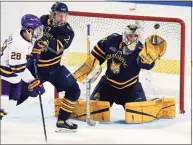  ?? David Zalubowski / Associated Press ?? Quinnipiac goaltender Keith Petruzzell­i, right, makes a glove save as defenseman Iivari Rasanen, center, jostles for position in front of the net with Minnesota State forward Cade Borchardt during the second period.