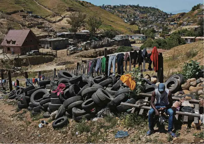  ?? Lalo de Almeida-13.abr.17/Folhapress ?? Haitiano lustra os sapatos na área externa de uma igreja evangélica na periferia de Tijuana, usada como abrigo por migrantes que querem entrar nos EUA; crise afastou migrantes