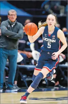  ?? GARY LANDERS/AP PHOTO ?? UConn guard Paige Bueckers (5) leads the break as head coach Geno Auriemma watches from behind during a Feb. 20 game against Xavier in Cincinnati.