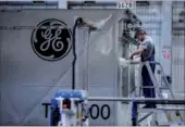  ?? GETTY IMAGES / BLOOMBERG ?? An employee unwraps turbine components inside a General Electric Co power plant in Veresegyha­z, Hungary.