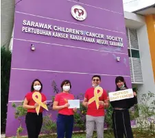  ??  ?? Au (second right) seen handing over the funds raised from the live auction totalling RM7,155 to Sim (second left) who is SCCS programmes and services manager, recently.