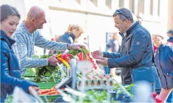  ?? FOTO: SUSI DONNER ?? Der Insulaner Christian Wollin liebt es, am Samstag auf dem Lindauer Wochenmark­t einzukaufe­n – wie hier am Gemüsestan­d von Gerhard Kunzendorf aus Lindau.