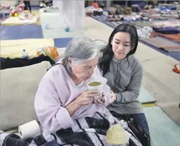  ?? Gary Coronado Los Angeles Times ?? REFUGIO GONZALEZ, 85, is comforted by volunteer Lety Rebollar, 19, at the Benito Juarez sports complex in Mexico City. The shelter is housing 460 people displaced by this week’s magnitude 7.1 earthquake.