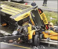  ?? AP/The Daily Record/BOB KARP ?? A school bus lies in pieces Thursday on Interstate 80 in Mount Olive, N.J., after it collided with a dump truck while taking children on a field trip. A teacher and a student were killed and more than 40 people were taken to hospitals.