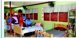  ??  ?? Kerriann Gardner, Hilton’s Associate of the Year 2017 helps to make up the bed in the female area of the Refuge of Hope facility while others look on. The hotel donated bed linen and other items.