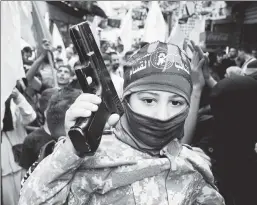  ?? ?? Bad education: A Palestinia­n boy wears military-style fatigues as others at his refugee camp dance in celebratio­n of Hamas’ massacre Oct. 7.