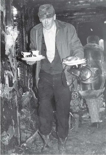  ?? DON HEALY ?? An unidentifi­ed survivor of the Feb. 10, 1974, Rosedale Manor apartment blaze in Regina carries out some of his scorched belongings. The blaze started in the early morning and led to the death of three people.