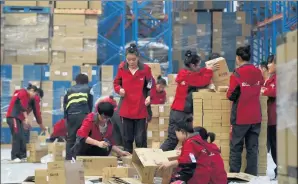  ??  ?? Workers of online marketplac­e JD.com check goods at a warehouse in Langfang, Hebei province.