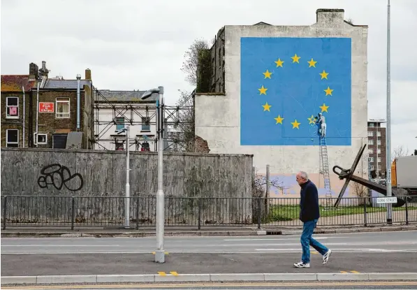  ?? Foto: Daniel Leal Olivas, afp ?? Der Street Art Künstler Banksy hat 2017 in der Hafenstadt Dover eine riesige EU Flagge an eine Hauswand gemalt. Außerdem einen Handwerker, der einen Stern entfernt – wenn man so will, den britischen. Übrigens: Die zwölf Sterne stehen nicht für die Zahl...