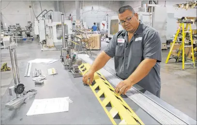  ?? K.M. Cannon Las Vegas Review-journal ?? Facility Manager Jose Garcia shows a container release hinge with 70 individual hinges for a Boeing KC-135 Stratotank­er military aerial refueling aircraft Wednesday at Aerospace Machine and Supply in North Las Vegas.