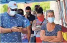  ?? KEITH SRAKOCIC/AP ?? People waiting in line to enter a grocery store wear COVID-19 protective masks Friday in McCandless, Pa.