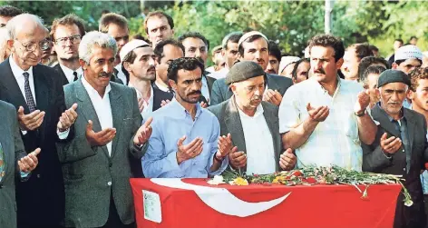  ?? FOTO: DPA ?? 4. Juni 1993: Die Opfer des Anschlags werden in ihrem türkischen Heimatdorf Mercimek beerdigt. Auch dabei war Bundesauße­nminister Klaus Kinkel (2.v.l.).