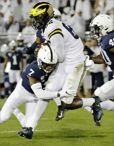  ?? Associated Press ?? Penn State safety Jaquan Brisker tackles Michigan’s Nick Eubanks Saturday night in a meeting of Top 25 teams won by the Nittany Lions, 28-21, at Beaver Stadium in University Park, Pa.