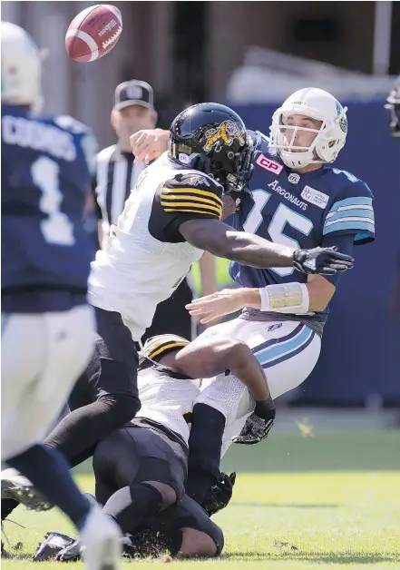  ?? — CP ?? Argos quarterbac­k Ricky Ray gets the pass off under pressure from Tiger-Cats linebacker­s Simoni Lawrence and Larry Dean during Sunday ‘s contest. Ray passed for 506 yards in a 32-15 victory.