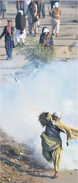  ??  ?? Versuche, eine Blockade von Islamisten in Islamabad aufzulösen, scheiterte­n zunächst. Demonstran­ten warfen Tränengas zurück.