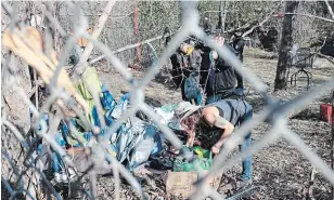  ?? MATTHEW P. BARKER EXAMINER FILE PHOTO ?? People pack up their belongings after an encampment off Wolfe Street in an area known as the Hole in the Fence is taken down on Nov. 6, 2020.