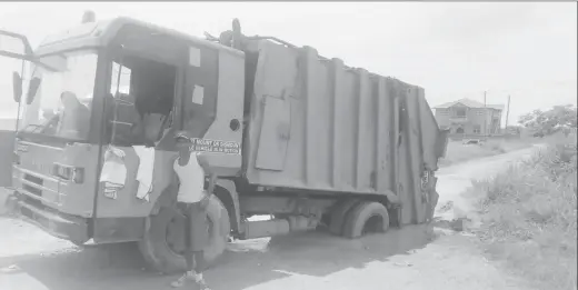  ??  ?? This garbage truck became stuck in a slushy pothole.