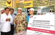  ?? FRIZAL/JAWA POS ?? PEDULI: Direktur Utama Bank Jatim R Soeroso (kiri) dan Ketua Paguyuban PKL Embong Blimbing Surabaya H Maksum (dua dari kanan) dalam penyerahan bantuan di Surabaya kemarin.