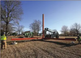  ?? (Arkansas Democrat-Gazette/Staton Breidentha­l) ?? Workers from Nabholz lower the sculpture “Standing Red” by American artist Tal Streeter into place on Dec. 4, 2019, at MacArthur Park in Little Rock.