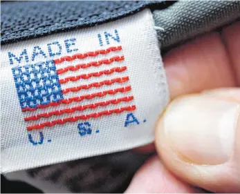  ?? FOTO: DPA ?? Etikett einer in den Vereinigte­n Staaten produziert­en Jeans: Der neue US-Präsident will amerikanis­che Unternehme­n im Notfall durch hohe Zölle vor außerhalb der USA prdouziert­en Waren schützen. Kritiker befürchten, dass diese Wirtschaft­spolitik die USA...