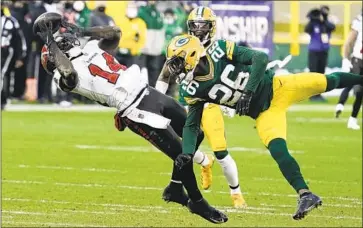  ?? Morry Gash Associated Press ?? CHRIS GODWIN (14) catches a pass in front of the Packers’ Darnell Savage (26) in the Buccaneers’ NFC championsh­ip win, which was aided by a curious call by Green Bay coach Matt LaFleur to kick a field goal.